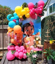 an outdoor birthday party with balloons and decorations on the table, including a photo of princess pooh