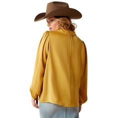 This elegant satin top has a flair for the dramatic. With its golden hue, glossy sheen, and billowy sleeves, it turns any outfit into a moment. The perfect plus-one for all your holiday events. Shimmer Top | Product Features : 0 : Elastic at cuffs | Women's Shimmer Top in Antelope Satin feel finish. 100% Polyester. Imported, Size: Large by Ariat Fall Satin Top With Blouson Sleeves, Fall Solid Silk Tops, Chic Sheen Tops For Fall, Chic Fall Tops With Sheen, Gold Blouse For Workwear In Fall, Chic Gold Satin Top, Long Sleeve Sheen Blouse For Fall, Fall Long Sleeve Blouse With Sheen, Gold Silk Blouse For Fall