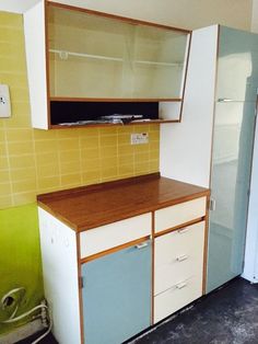 an empty kitchen with yellow and blue cabinets