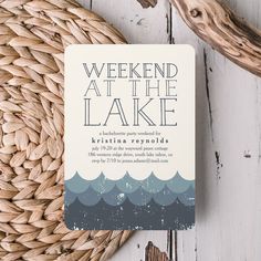 a card with the words weekend at the lake on it sitting next to a basket