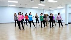 a group of women standing on top of a hard wood floor in a dance studio