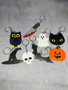 six halloween themed key chains with cats, bats and pumpkins on them in various colors