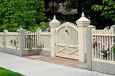 a white picket fence with pink flowers growing on it