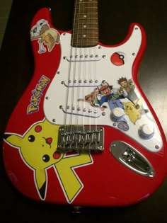 a red guitar with pikachu stickers on it