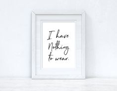 i have nothing to wear art print in white frame on wall above shelf with plant