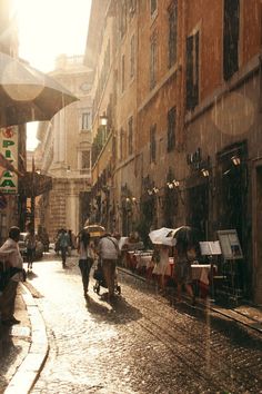 people walking down an alleyway in the rain with umbrellas over their heads,