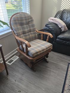 a living room with two leather chairs and a rug on the floor in front of a window