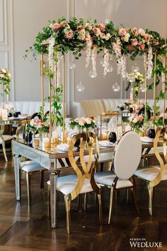 an image of a table setting with flowers and greenery on the tables in front of it