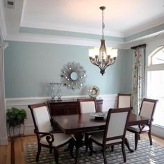 a dinning room table with chairs and a chandelier