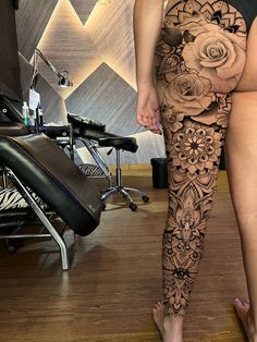 a woman's legs with tattoos and flowers on them