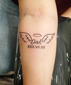 a person with a tattoo on their arm that says dad xxvix and wings