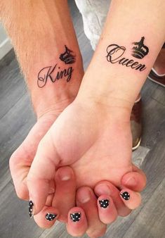 two people holding hands with tattoos on their arms and the words queen and king written in cursive font