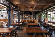 an empty restaurant with wooden tables and chairs