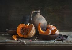 a still life with pumpkins and a pitcher