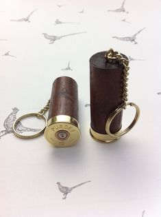 Solid walnut shotgun shell cartridge cap keyrings Here we have a handcrafted pair of shotgun shell cartridge cap keyrings made with  genuine used Purdey shotgun shell cartridge caps and a lovely piece of solid walnut. The keyring is a chain with a split ring and of high quality. I have shot the shells myself and discard any marked or scratched ones. The wood has been finished with a natural oil and the cap has been highly polished. Please check out our other shotgun shell items, including Hollan Winchester Shotgun, Bullet Casing Crafts, Shotgun Shell Crafts, Edc Bag, Shells Diy, Bullet Casing, Shotgun Shell, Crafts Jewelry, Natural Oil