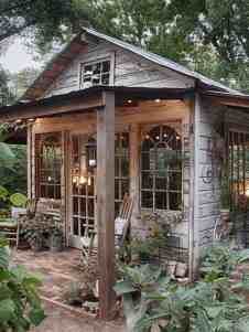 a small building with lots of plants in the front yard and patio area next to it