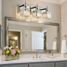 a bathroom vanity with two sinks and a large mirror over the sink that has flowers on it