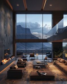 a living room with couches and tables in front of large windows that look out onto the mountains