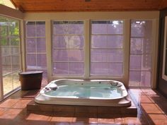 a large jacuzzi tub sitting in the middle of a tiled floored room