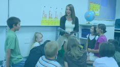 a woman standing in front of a group of children