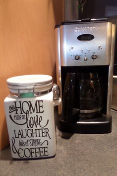 a coffee maker next to a glass jar with the words home is love on it