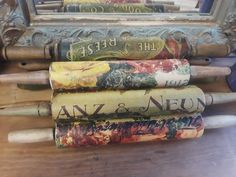 several old books are stacked on top of each other in front of a wooden table