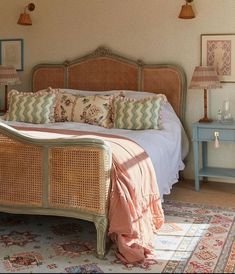 a bed with wicker headboard and foot board in a bedroom next to two lamps