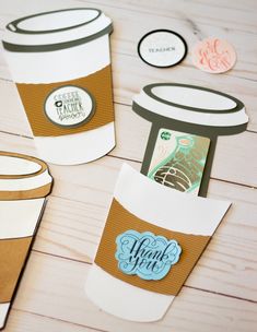 coffee cups with thank you tags on them sitting on a wooden table next to other items