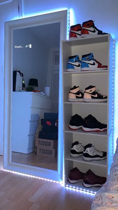 there is a closet with many shoes on the shelves and lights in the room behind it