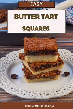 3 Butter Tart Squares stacked on a white plate with more butter tarts in a pan in the background.