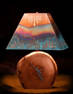 a lamp that is sitting on top of a wooden table with a painting on it