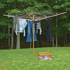 clothes hanging out to dry on a clothes line in the grass with a picnic table nearby