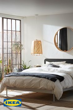 a bedroom with a bed, mirror and potted plants