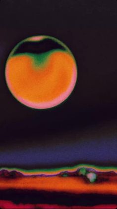 an orange and green object in the middle of a black background with other things around it