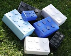 four lego blocks sitting in the grass on top of each other