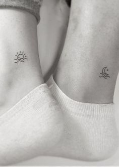 two small sun and moon tattoos on the wrists, both with their hands behind their backs