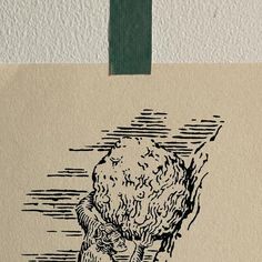 a piece of paper with an ink drawing of a man holding a large rock on it's side