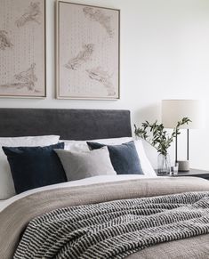 a bed with two paintings on the wall above it