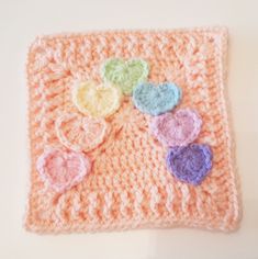 there is a crocheted square with hearts on it