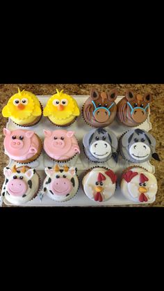 an assortment of cupcakes with farm animals on them