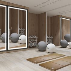 a room with mirrors, yoga mats and exercise balls on the floor in front of them