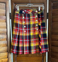 Vintage 1960's era plaid pleated skirt in great fall colors, double button front wrap design with fringed edge  Red, black, yellow  Inside is lined in a yellow acetate type material  Small mend around one button on inside flap * does not show on outside when buttoned  Overall good condition  Waist-26" Length- 21 1/2" Vintage Accordion Pleats Skirt For Fall, Vintage Plaid Pleated Skirt For Fall, Retro Plaid Pleated Skirt For Fall, Retro Skirt With Button Closure For Fall, Pleated Skirt Fall, Fall Skirt, Plaid Pleated Skirt, Womens Skirts, Fall Skirts