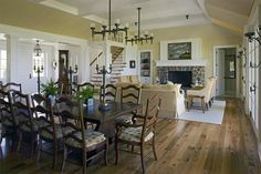 a dining room table with chairs and a chandelier hanging from it's ceiling