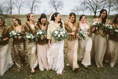 a group of women standing next to each other in dresses and fur stoles holding bouquets