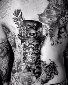 a man with tattoos on his back and chest is wearing a top hat, feathers, skull