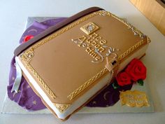 a cake that is sitting on top of a table next to a purple and red rose