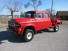 an old red truck parked in a parking lot