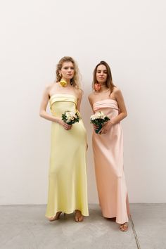 two women standing next to each other in dresses