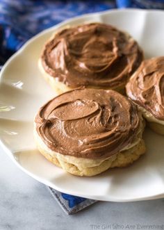 three cookies with chocolate frosting on a plate