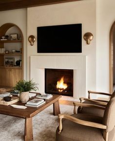 a living room filled with furniture and a fire place in front of a flat screen tv